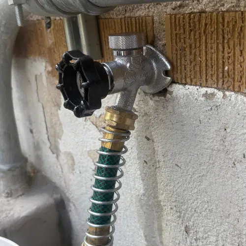 Outdoor hose bib installation on a brick home in Sugar House, Utah. Brass spigot with clean threading, mounted securely to siding.