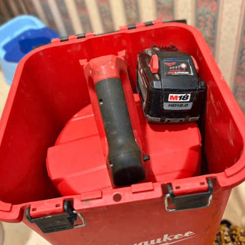 Professional plumber using drain auger tool to clear a shower drain clog in West Valley City.