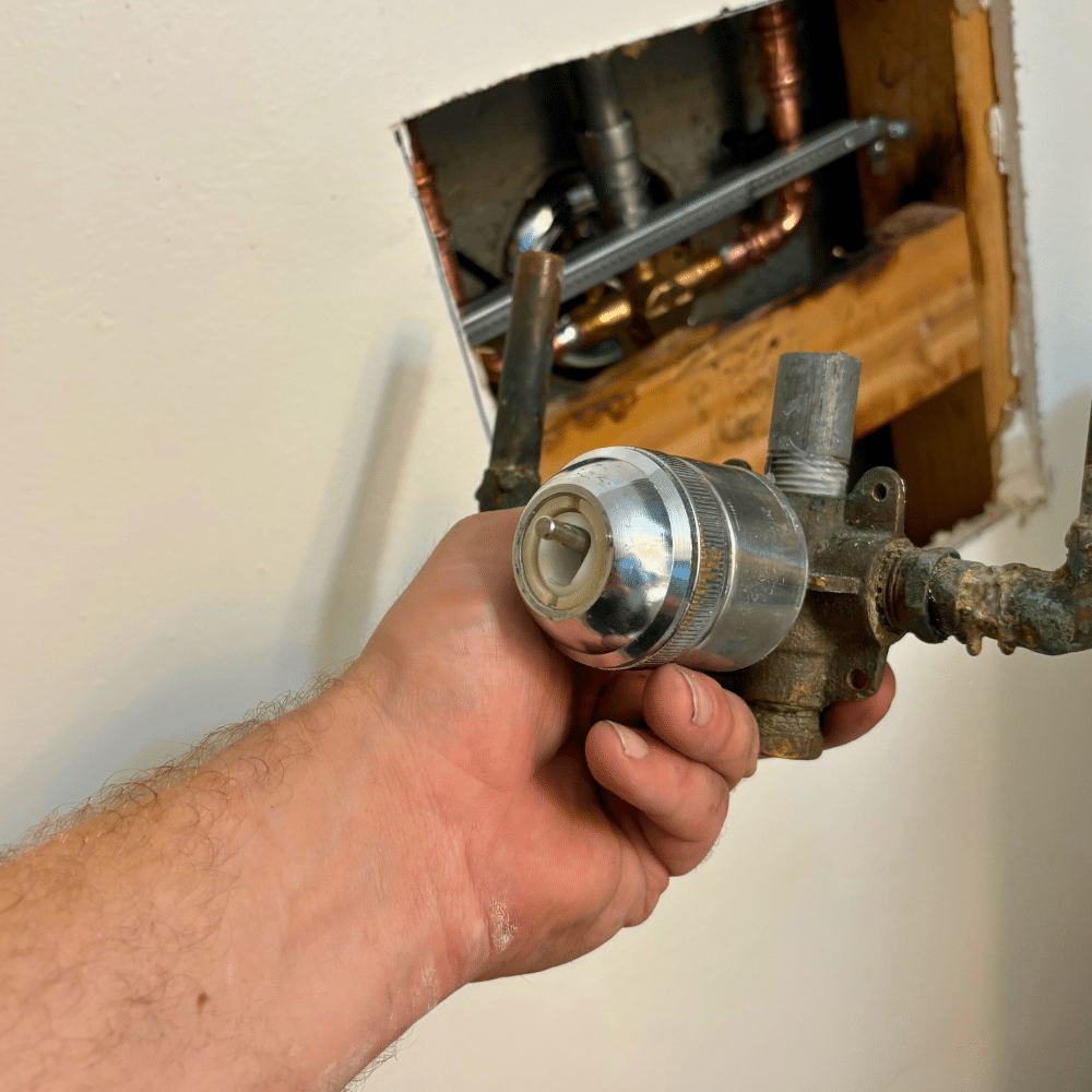 Sealing and finishing repaired shower handle trim during a shower repair in Sandy Utah