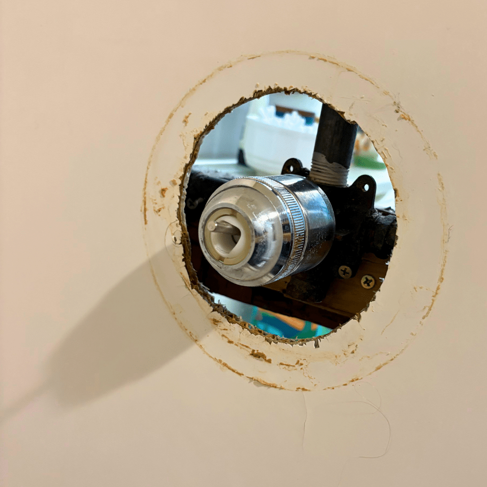 Sealing and finishing repaired shower handle trim during a shower repair in Sandy Utah