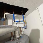 Blue PEX softener loop and shutoff near water heater supporting relocated Millcreek softener piping work.
