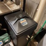 Black brine tank with Mountain Man Plumbing sticker beside mechanical room equipment Park City