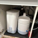 Customer Cloud reverse osmosis system and storage tank installed under kitchen sink in Salt Lake City