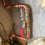 New brass ball valve with red handle on copper main line after replacement in Salt Lake City home plumbing access