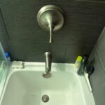 Finished Kohler single-handle tub shower trim and spout reinstalled over the tub in a Sandy Utah bathroom.
