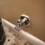 New chrome quarter-turn toilet shutoff valve with escutcheon installed on the bathroom wall in West Jordan