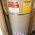 Close-up of aging A.O. Smith ProMax labels and EnergyGuide on original condo water heater in Salt Lake City before haul-away.
