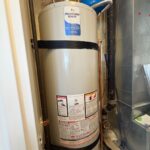 New Bradford White tank water heater strapped in a Salt Lake City condo mechanical room with relief piping and expansion tank nearby.