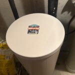 Closed brine tank lid with Mountain Man Plumbing sticker after full salt fill on a water softener install in Draper Utah.