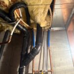 Copper softener bypass loop with yellow-handled valves and blue PEX risers supported beside black drain piping in a Draper basement.