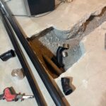 Long black pipe sticks, solvent can, and fittings beside an open slab pit for sewer connections in Draper.