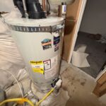 Full view of new 50-gallon power vent water heater on drain pan with gas flex and seismic strap in South Jordan