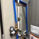 Completed wall PRV install on blue and white piping beside water heater after North Salt Lake pressure repair