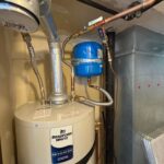 Top of new Bradford White water heater showing vent, copper lines, flex connectors, and blue expansion tank in Salt Lake City condo.