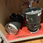 Failed gray disposal beside new half-horsepower InSinkErator unit on the cabinet floor before install in Midvale.