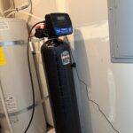 Full Holts Titan VI softener tank plumbed beside water heater in Midway utility room