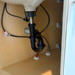 Under-sink P-trap, drain assembly, and supply lines after bathroom faucet work in a Midway vanity cabinet