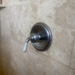 Restored single-handle chrome shower valve on beige tile after cartridge replacement in Salt Lake City bathroom.
