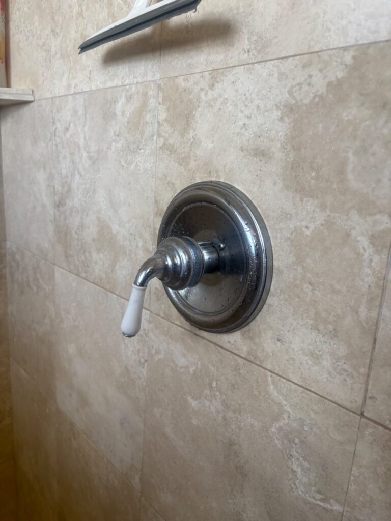 Restored single-handle chrome shower valve on beige tile after cartridge replacement in Salt Lake City bathroom.