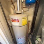 Original A.O. Smith ProMax tank water heater still connected before removal in Salt Lake City downtown condo mechanical room.