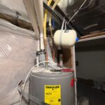 Older gray water heater before haul-away with expansion tank and open top piping in South Jordan mechanical area