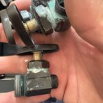 Corroded multi-turn fixture shutoff valves with green mineral buildup held after removal during Park City UT leak repair work