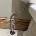 Braided toilet supply hose on a new angle stop at the floor escutcheon after shutoff replacement in Park City Utah