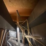 Cluster of polybutylene pipes and fittings above mechanical equipment in open Sandy basement utility space