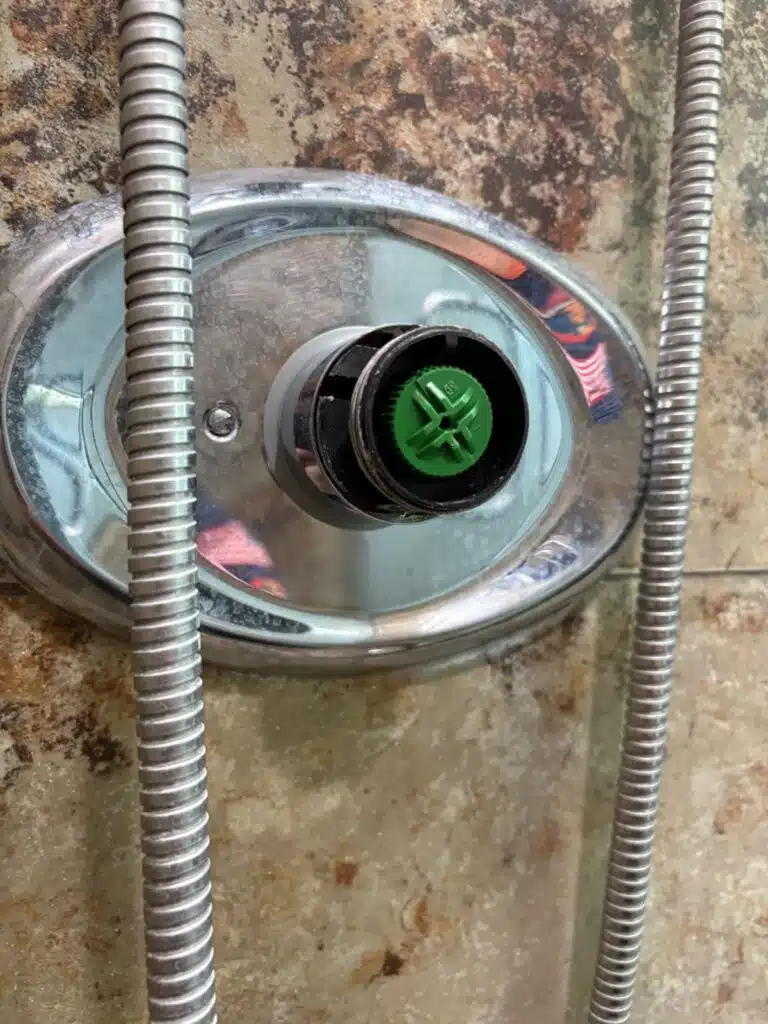 Chrome oval shower escutcheon with the green temperature control visible at center during a Grohe service in Sandy, Utah
