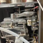 Open Rinnai RUR cabinet with burner heat exchanger fan and gas train during Salt Lake City water heater repair