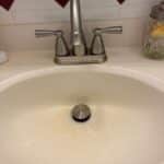 New brushed nickel two-handle bathroom faucet and pop-up drain installed on a vanity sink in Salt Lake City