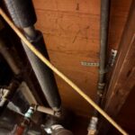 Insulated supply piping and mechanical connections in a crawl or utility space related to laundry hookup