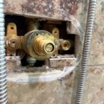 Brass Grohe shower valve stem and threaded face exposed after housing removal in Sandy Utah bathroom