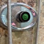 Chrome oval shower escutcheon with green temperature control visible at center during Sandy UT Grohe service