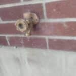 New brass Woodford-style frost-free hose bib mounted and sealed on exterior brick wall after install in Sandy