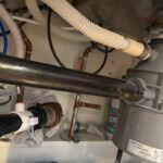 Under-sink disposal, corrugated drain hose, and copper supply lines after plumbing work