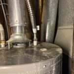 Close-up of braided stainless connector nutted to water heater port after secondary line valve service in West Jordan.